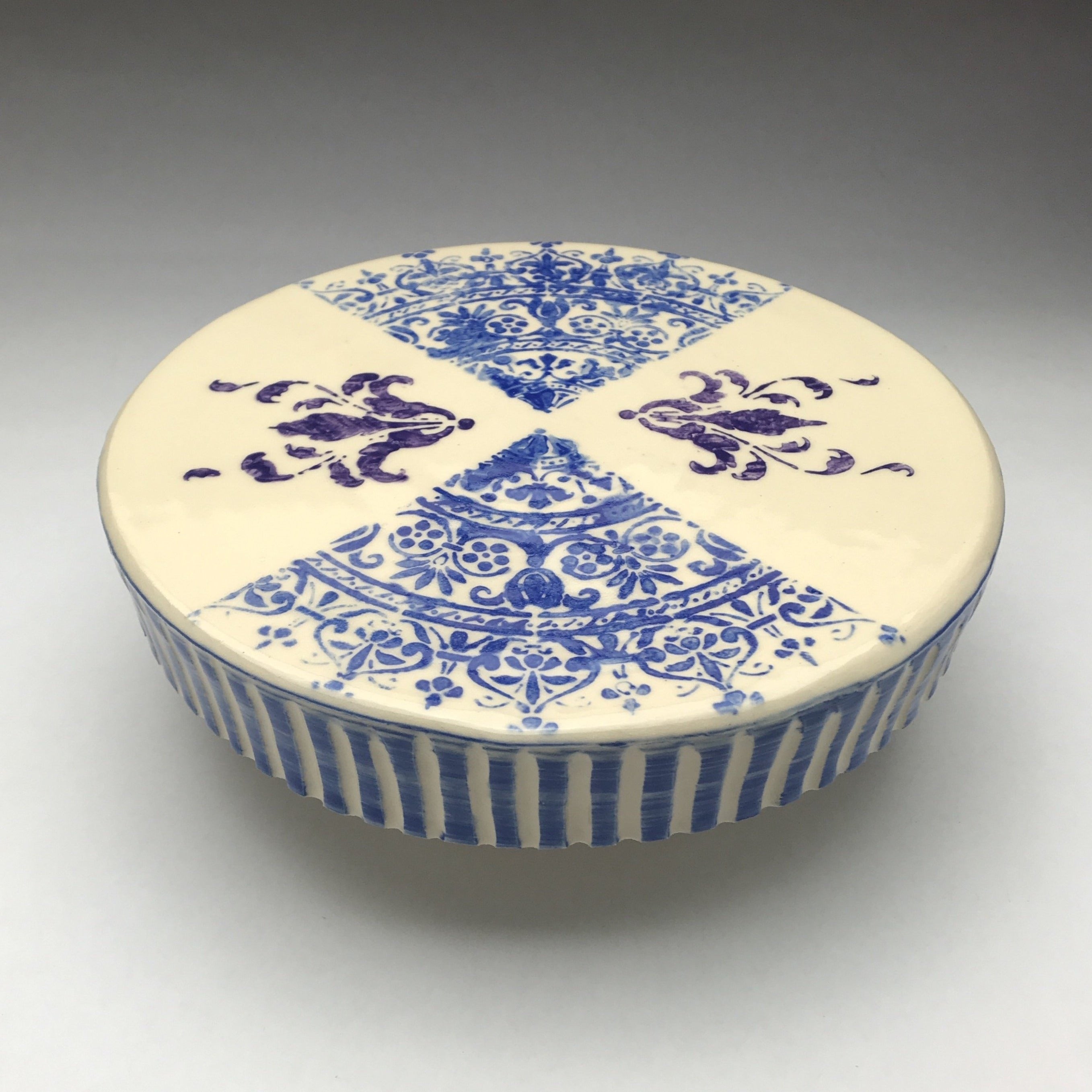 pottery cake stand with blue lace pattern,  purple flourishes and blue striped border