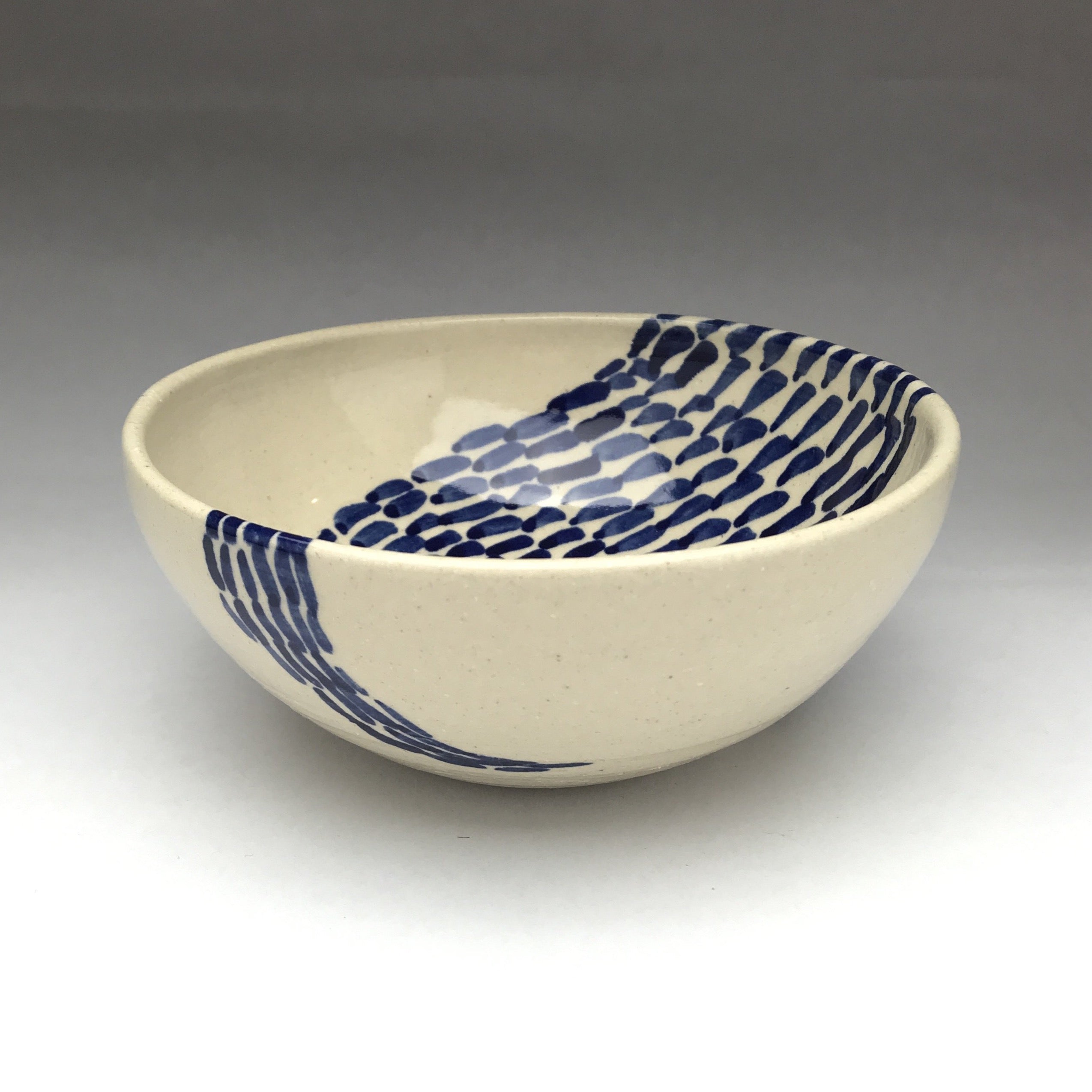 white ceramic bowl with cobalt blue patterns of lines and dots
