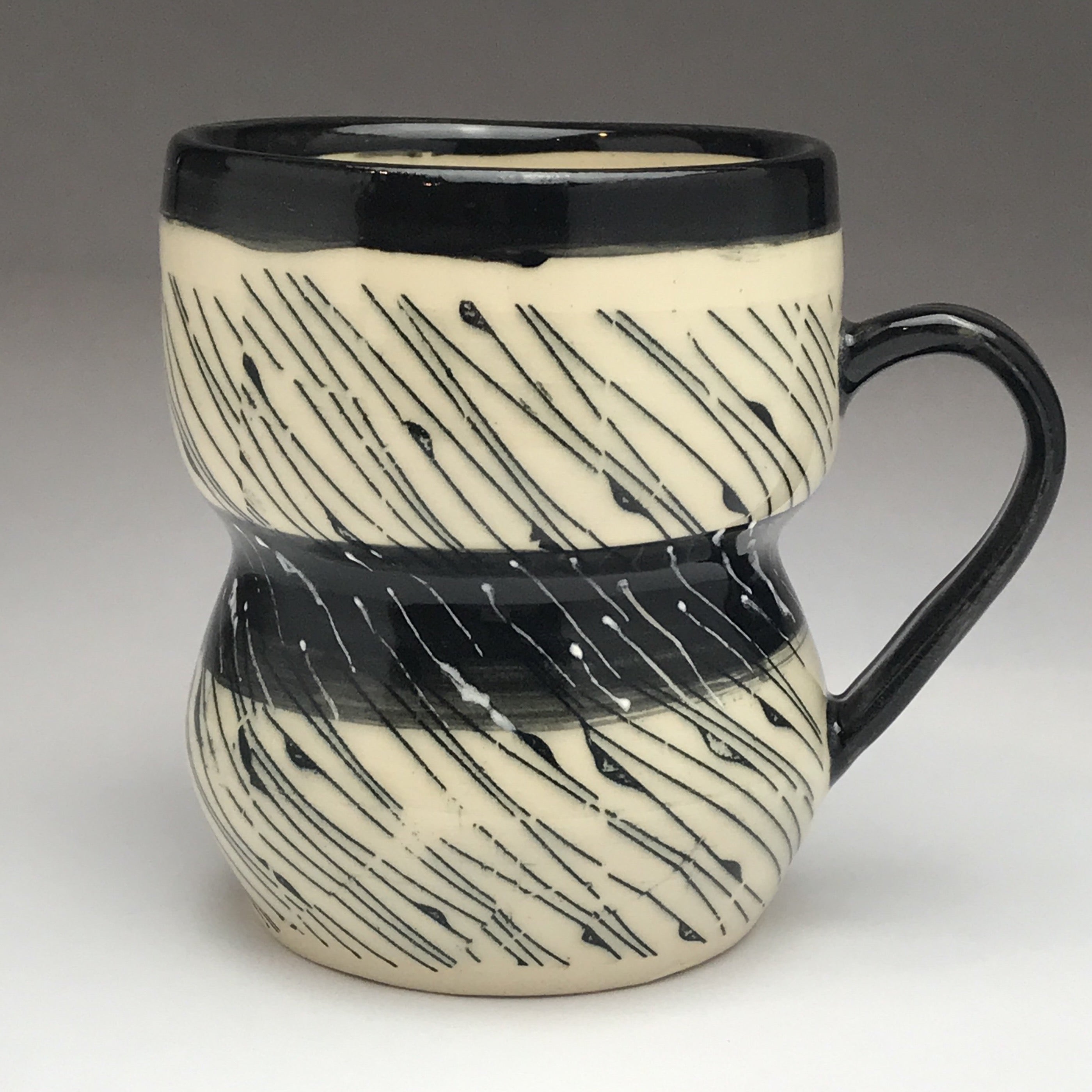White coffee or tea mug with black and white diagonal line design.