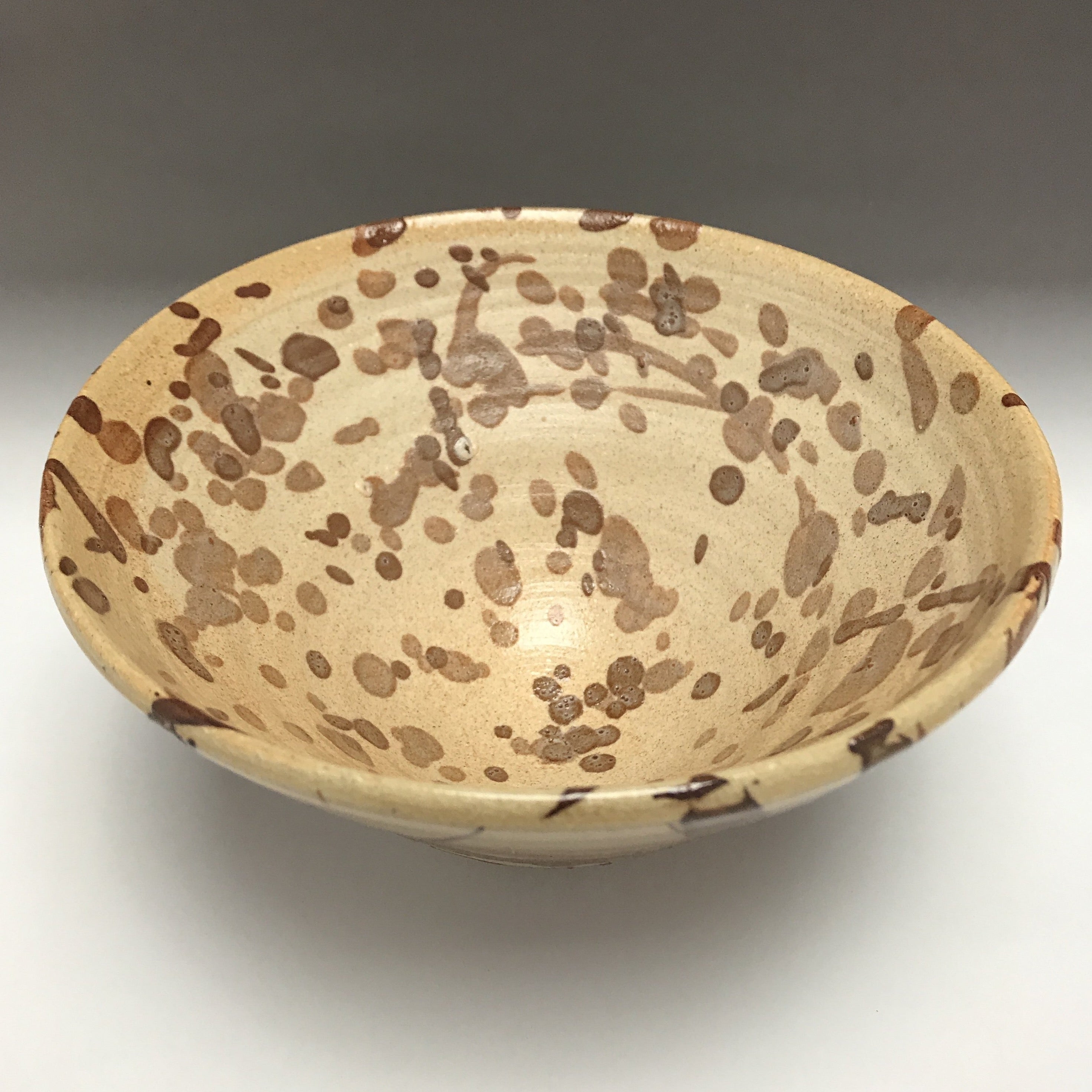 ceramic pottery bowl pale brown with dark brown splatters and splashes