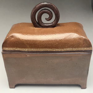 rich brown rectangular box with curved lid and dark brown handle with spiral pattern