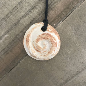 Round pendant necklace with koru spiral. Made of clay, off white color.