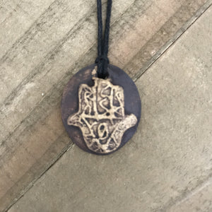 Oval pendant necklace with Hand of God or Hamsa. Made of clay, brown color.