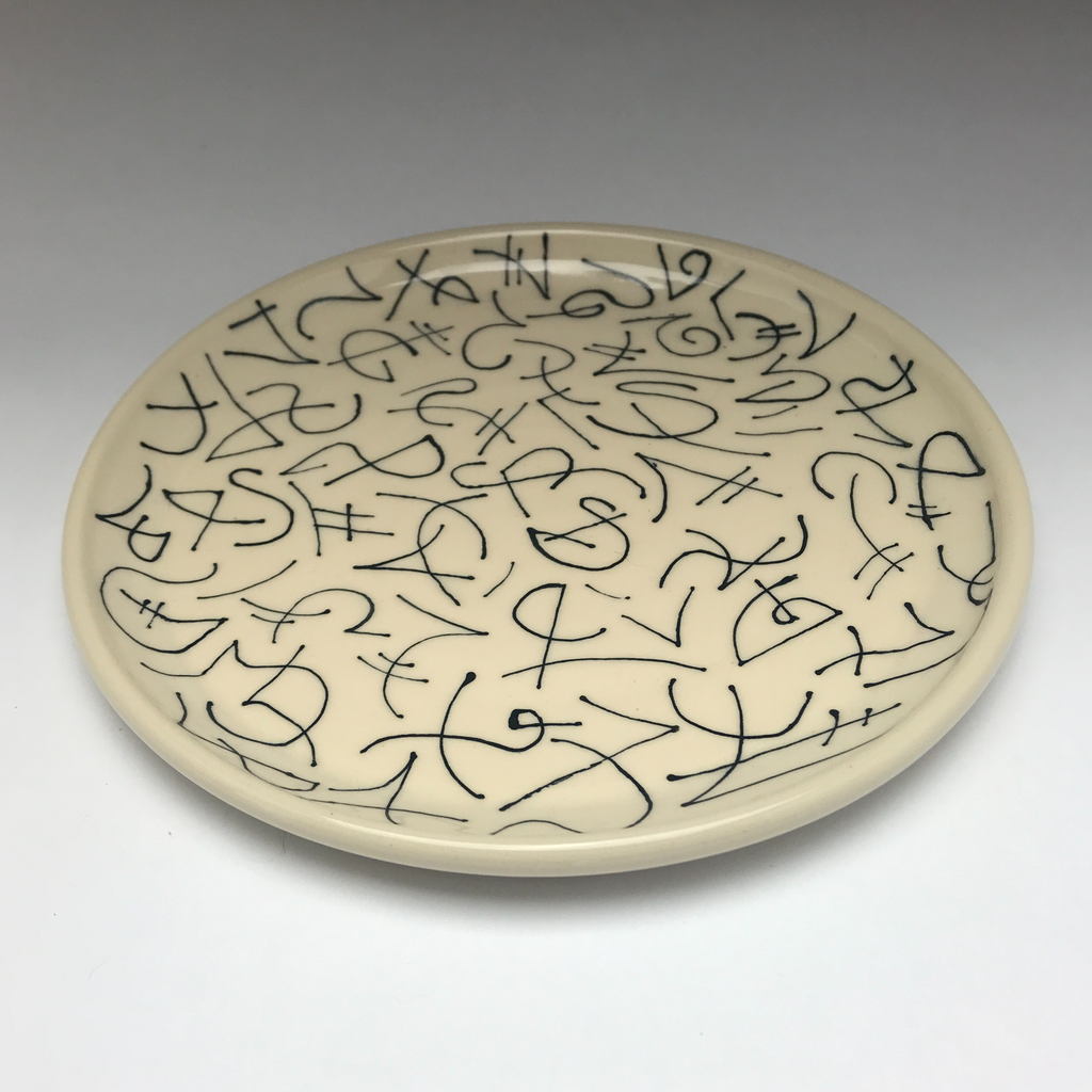 white ceramic bowl with black graphic linework reminiscent of graffiti